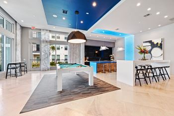 A modern interior with a pool table and bar area.